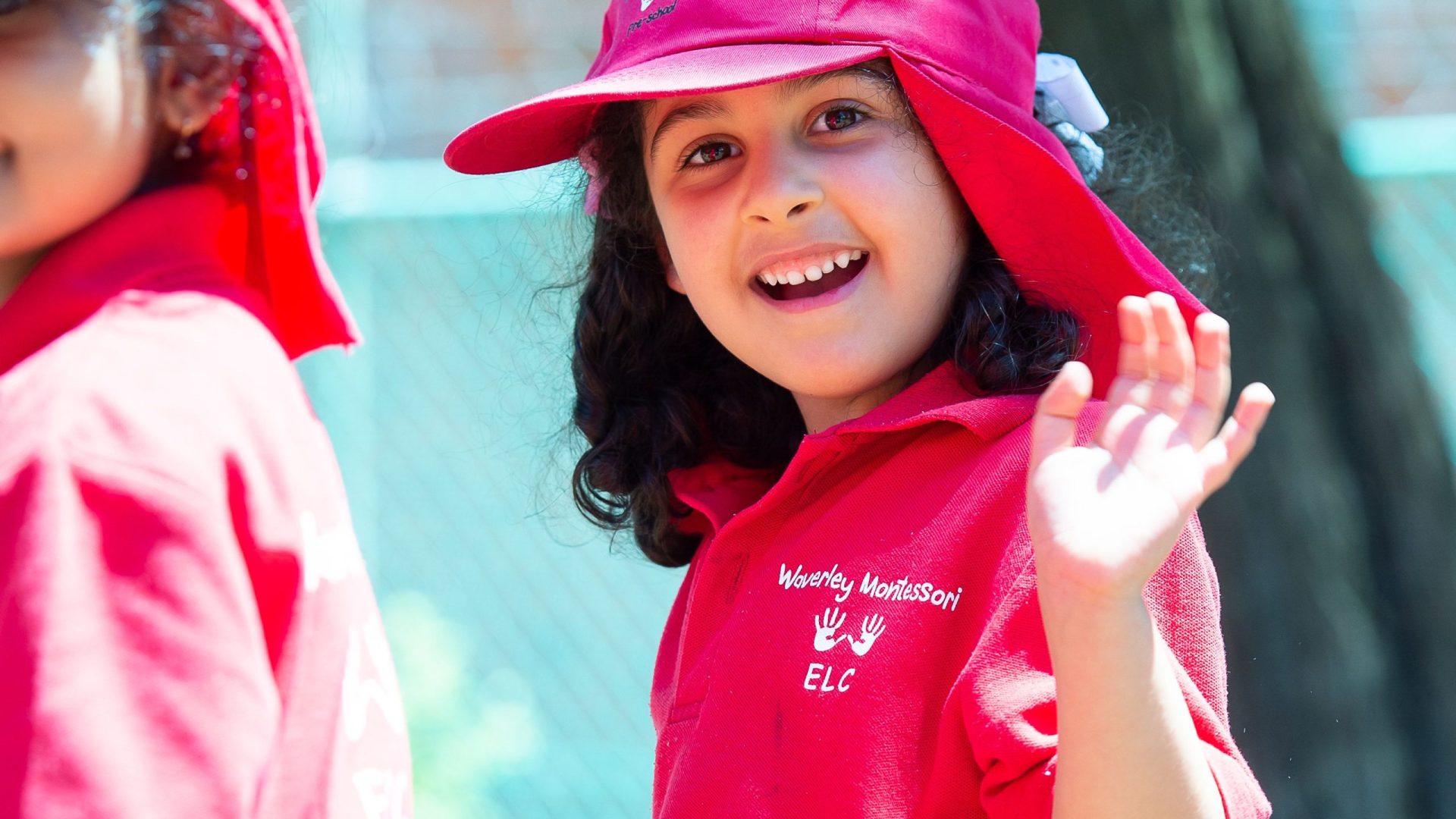 Child in Waverley Montessori uniform waving